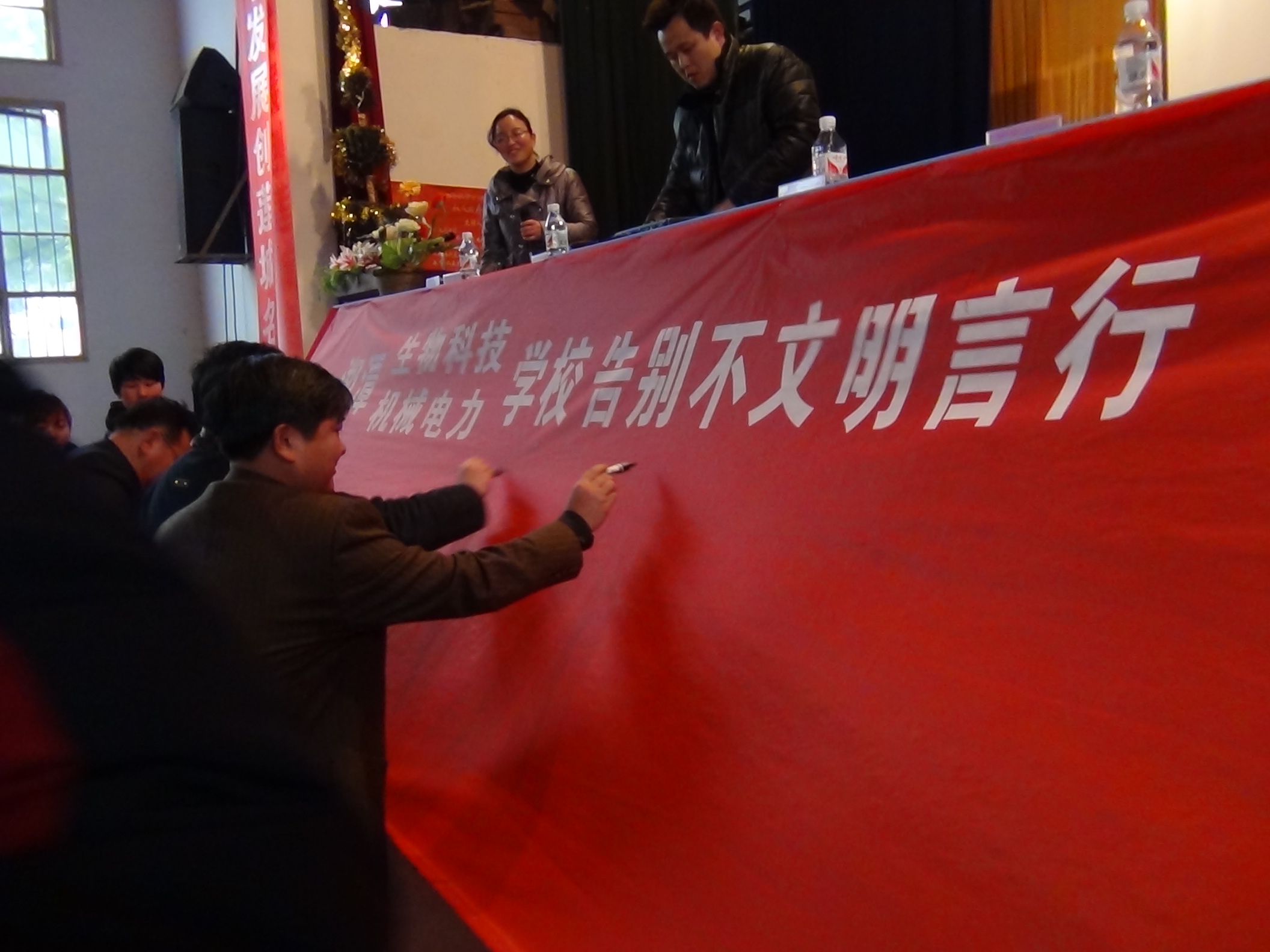 9校领导在10米长的印有“告别不文明行为，建设绿色校园”的横幅上郑重地签上的自己的名字.JPG